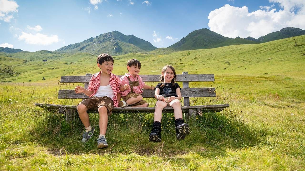 bambini si siedono su una panchina al pascolo in Val Casies